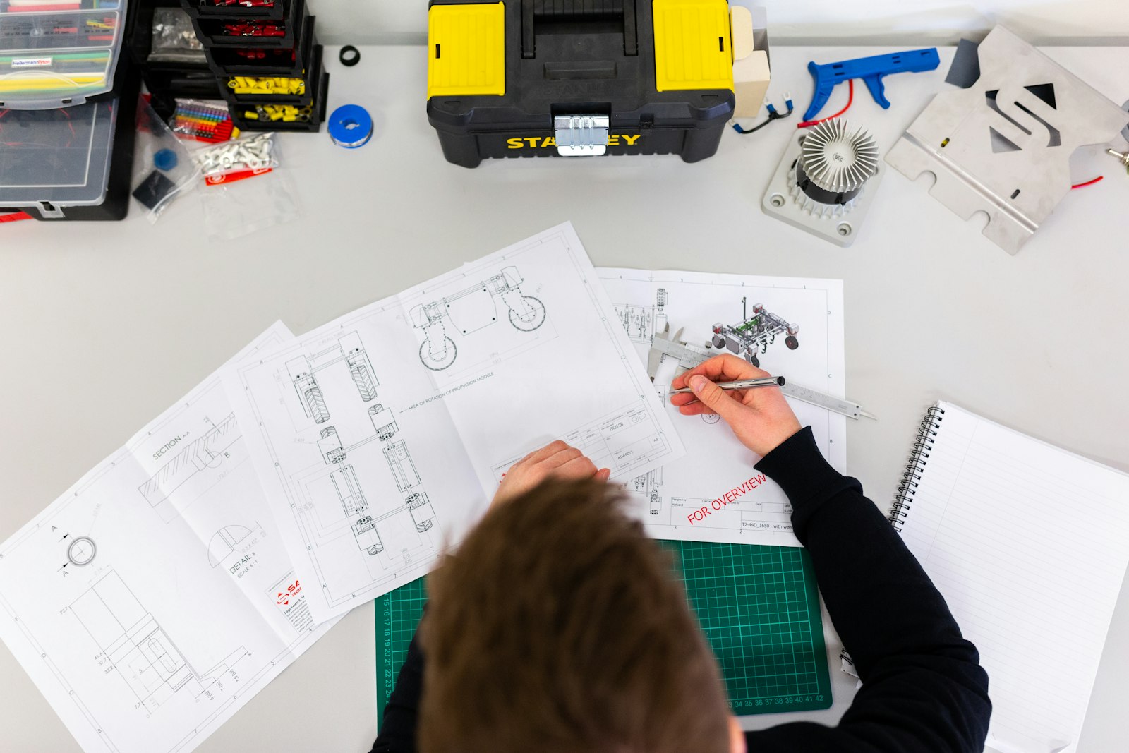 Engineering drawings and components on a workbench